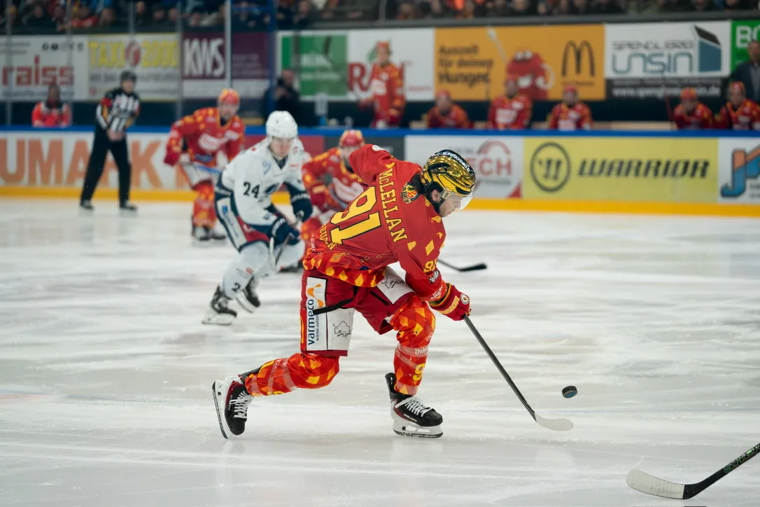 Zwei Eishockeyspieler kämpfen auf dem Eis um den Puck.